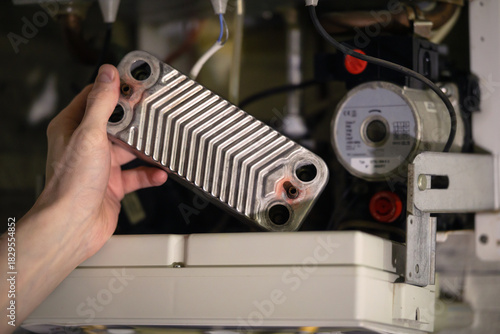 Replacing the heat exchanger in the boiler. The repairman fixes the heating boiler.