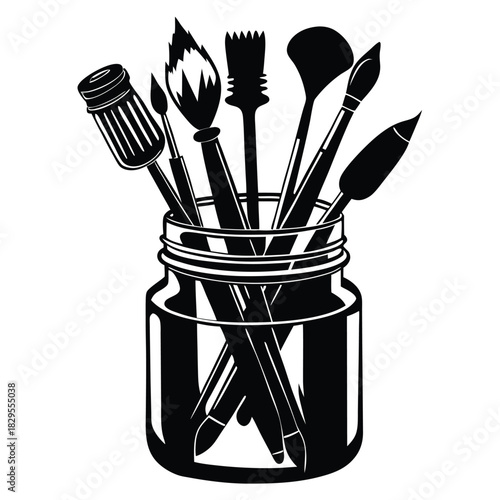 Various black paintbrushes are artistically arranged inside a clear glass jar, showcasing artistic tools