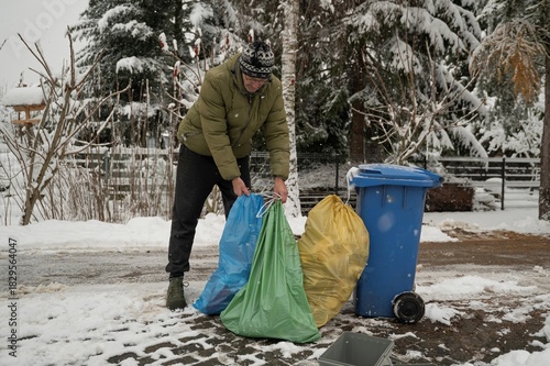 dorosła osoba dbająca o recykling wyrzuca posegregowane odpady