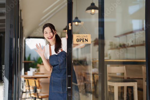 Young Asian woman cafe owner welcoming customers