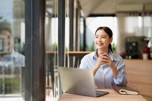 Fotografia Young woman enjoying coffee break while working remotely
