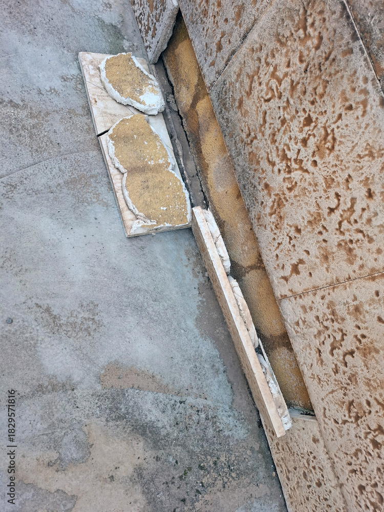 Φωτογραφία Finishing tiles have fallen off the wall of a house and need urgent repair work
