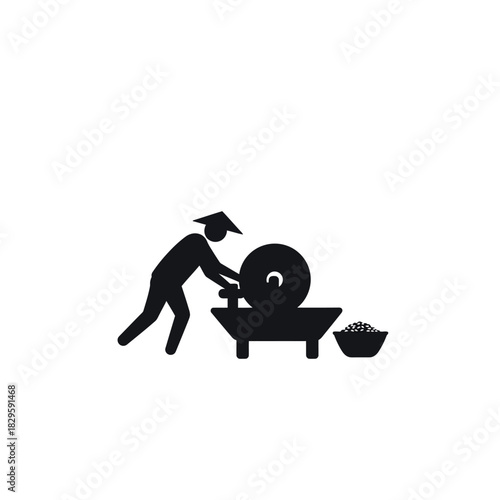 Man Grinding Grain with Traditional Tool.