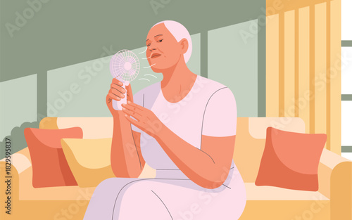 Elderly woman using a portable fan to cool down on a hot day