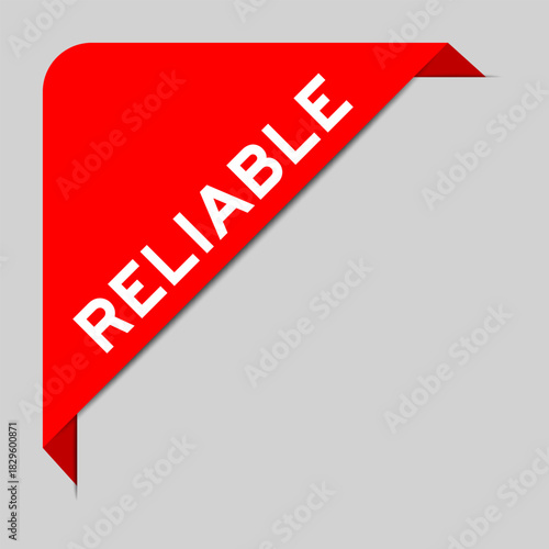 Red color of corner label banner with word reliable on gray background