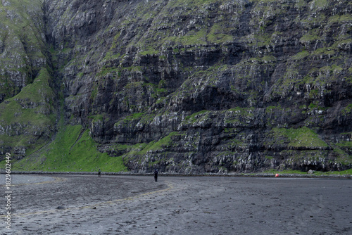 Traveler on the black beach at Saksun, capturing a classic Faroe Islands experience.