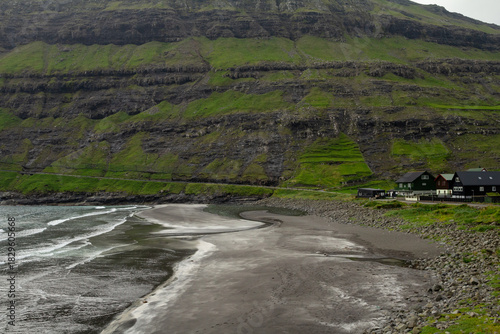 Dark volcanic sand beach in Tjørnuvík facing the wild Atlantic—classic Faroe Islands scenery.