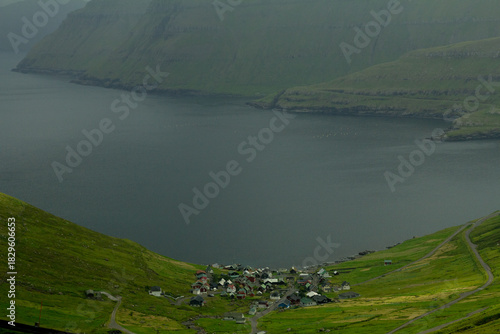 Tiny Faroese village nestled beneath towering green mountains—authentic island culture and hiking beauty.