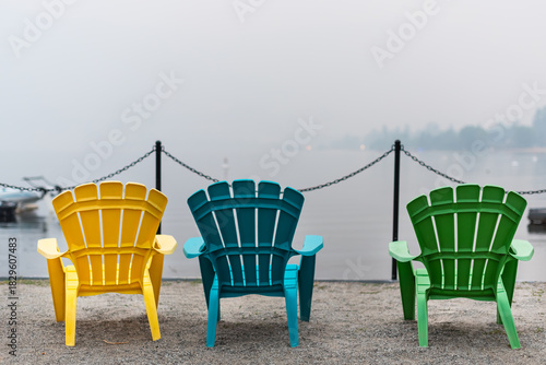 Colorful beach chairs facing a lake view obscured by summer wildfire smoke