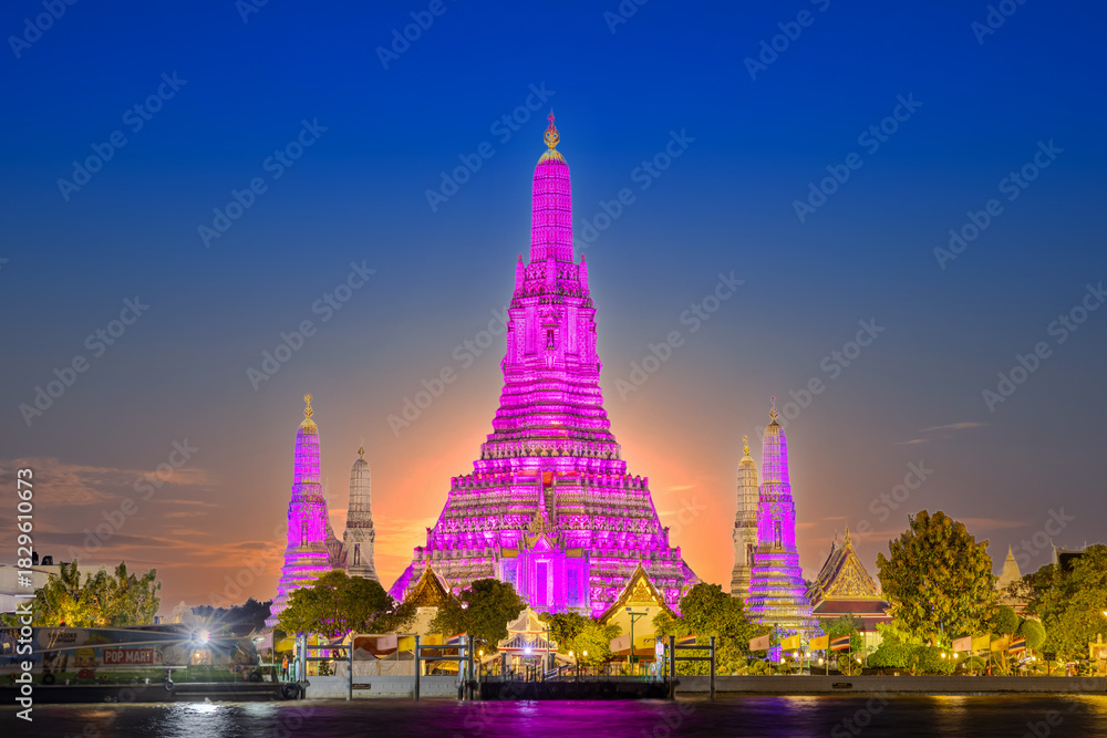 Fototapeta premium 26 November 2025 Beautiful Sunset colours of Thai Temple Wat Arun on Chao Phraya River in BKK Bangkok Thailand. The magic colourful neon light display on the temple at sunset is magical.