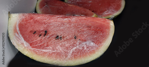 Slices of watermelon on a black plate, close-up