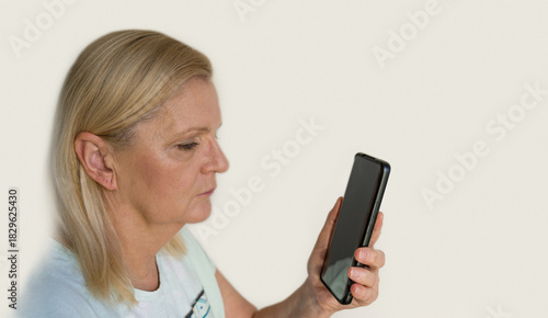 Senior woman is struggling with an smartphone technology