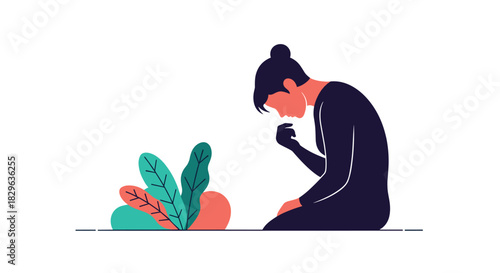 A person in a dark outfit sits with their head bowed and hand on their chin next to plants.