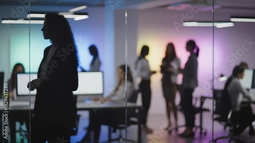 Silhouetted Colleagues Collaborate in Modern Office Environment
