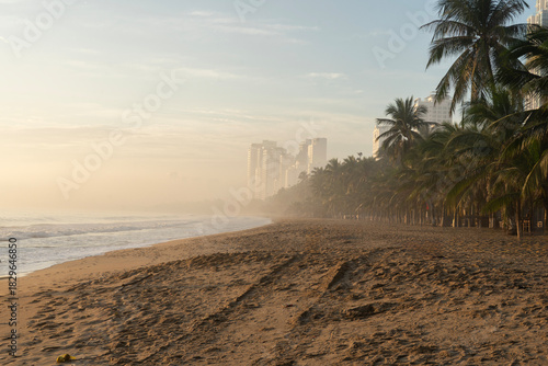 Fototapeta Naklejka Na Ścianę i Meble -  Beautiful tropical beach with palm tress at sunrise.