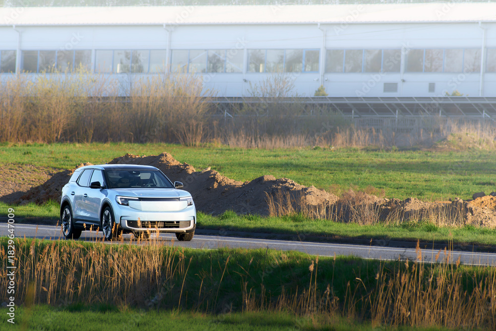 Fototapeta premium Electric car with driver on rural drive