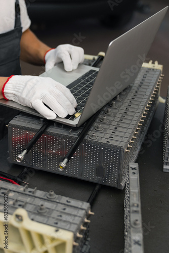 Serviceman repairs electric battery pack of hybrid car
