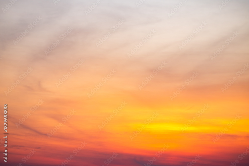 Fototapeta premium Sunset or sunrise sky with a vibrant gradient of orange, gold, and soft blue. Clear atmosphere with wispy clouds. Peaceful, natural light background. hope, freedom, new day and inspirational Concepts