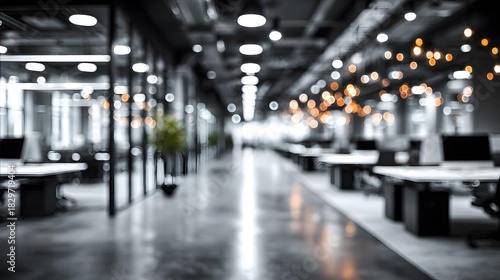 Blurred abstract office background features an open plan workspace with bright white and grey tones in an out of focus business environment.