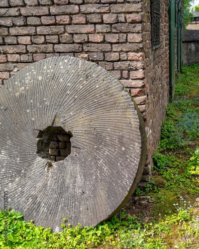 Foto old millstone on a brick wall