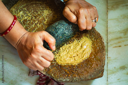 Quadro su tela Indian woman grinding spices on traditional sil batta stone grinder