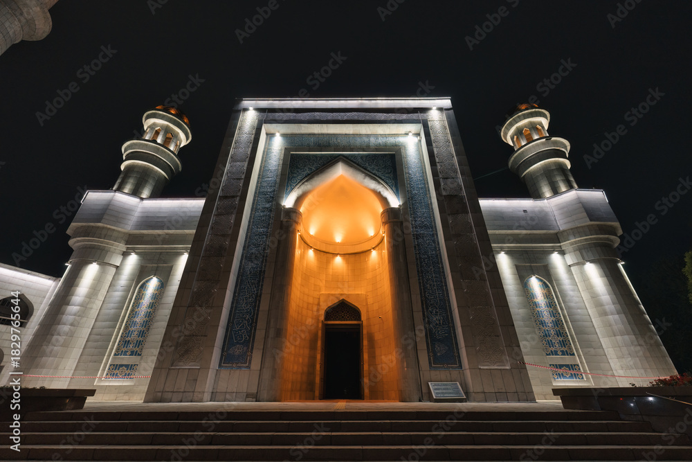 Fototapeta premium Illuminated facade of Central Mosque with entrance lighting in the night at Almaty, Kazakhstan