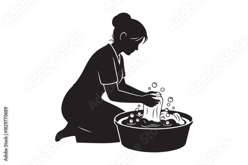 Silhouette of a woman washing clothes in a basin