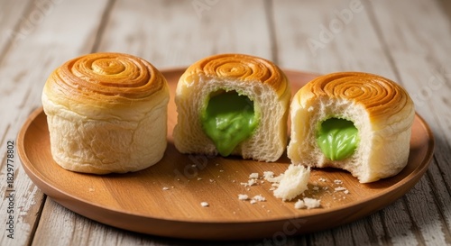 Artisanal pandan buns revealing a delightful, bright green filling on a wooden plate