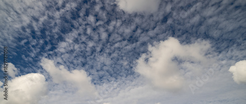 small and large white clouds in dark blue sky