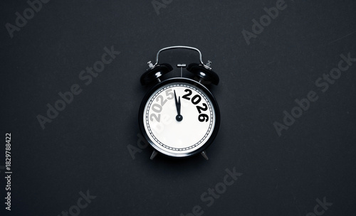 A clock showing the transition from 2025 to 2026 on a dark background representing a new year countdown concept symbolizing time change preparation motivation and fresh goals for the upcoming year.