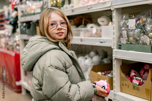 A girl in a store among Christmas decorations. Preparing for the New Year and Christmas. Buying decorations and gifts.