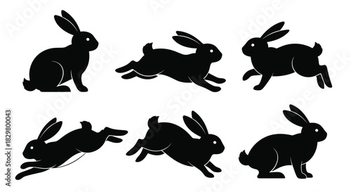 A set of black rabbit silhouettes in various dynamic poses such as sitting running and leaping isolated on a white background.