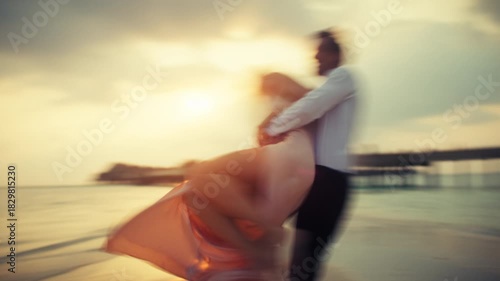 Cinematic slow-shutter sequence of a man chasing, lifting, and spinning his partner in a romantic, dreamlike moment on the beach. Highlights love, joy, and connection during a tropical sunset getaway.