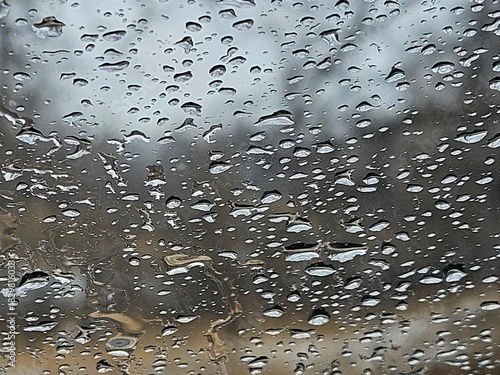 Extreme closeup of the shape and texture of raindrops on a window.