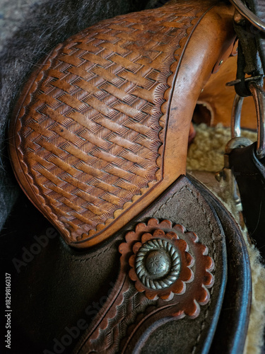 Extreme closeup of the leatherwork and craftsmanship on the pommel or swell of a western style saddle..