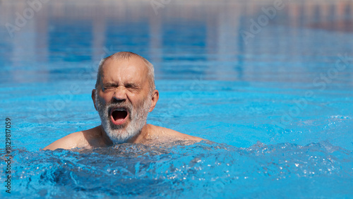 An adult man swims breaststroke in a swimming pool.
