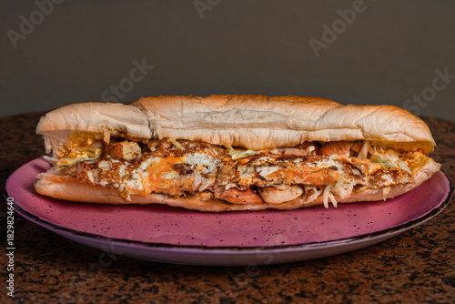 Long sandwiches with chicken breast, eggs, cabbage, cheese and dressing on plate