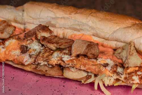Long sandwiches with chicken breast, eggs, cabbage, cheese and dressing on plate