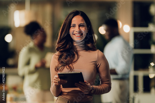 Female professional smiling holding digital tablet in office