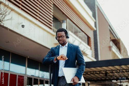 African american businessman checking time wearing headphones