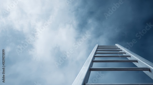 Fototapeta Naklejka Na Ścianę i Meble -  tall extension ladder pointing upward, concept of climbing to success, bright blue sky with clouds
