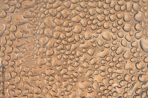 Abstract background with a macro view of water droplets on a copper-colored surface, creating a natural pattern of moisture and condensation.