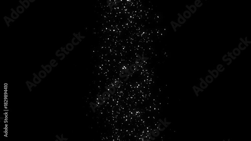 White Particles Form a Vertical Cascade on a Black Background.