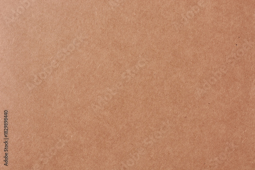 close-up of brown book cover texture, reddish-brown paperboard surface with grainy pattern, abstract background for design in full frame