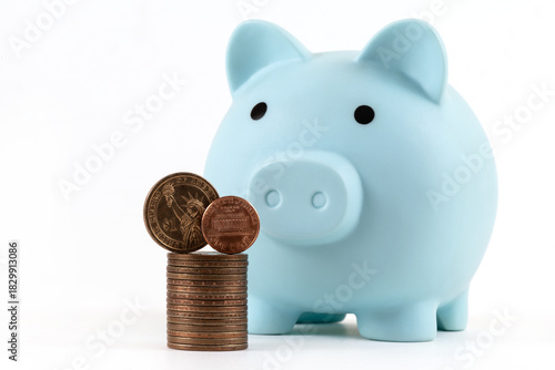 American 1 cent, US $1 coin and a blue piggy bank on a white background