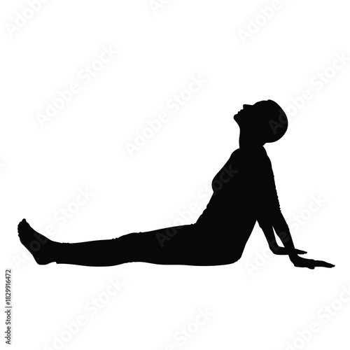 Silhouette of a woman practicing yoga in the cobra pose position