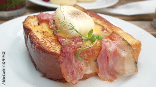 Poached egg on toast with crispy bacon - breakfast close-up