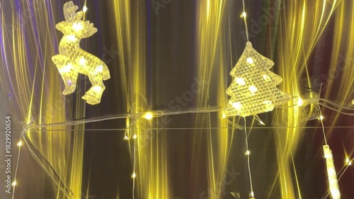 4k footage of hanging christmas decoration with beautiful interactive icicle lights and reflections. Crystal christmas decoration of tree, bells, reindeer and baubles illuminated with lights.