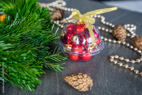 Close-up of a handmade Christmas wreath before decoration, surrounded by various festive ornaments in soft focus. Cozy home preparation for a traditional holiday craft