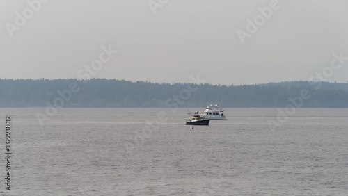 View of a fishing boat on a misty day cruising on the calm waters of Puget Sound near Seattle, Washington, USA